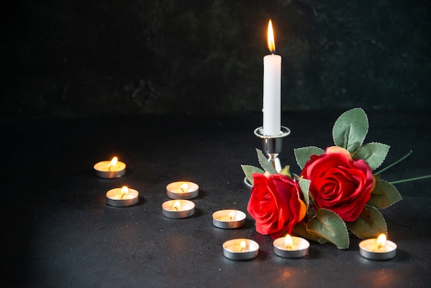 Vue avant des bougies allumées comme mémoire pour une surface sombre tombée