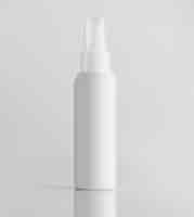 Photo gratuite vue avant bouteille en plastique blanc avec pulvérisateur sur un mur blanc