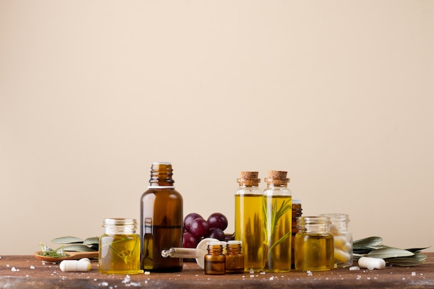 Vue avant des bouteilles en plastique avec de l'huile et des médicaments sur la table