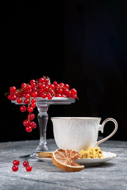 Vue avant des canneberges rouges fraîches avec une tasse de café sur le bureau léger fruit berry café citron