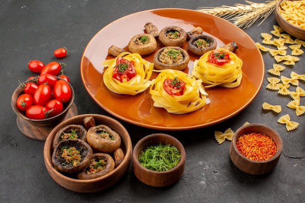 Vue avant de champignons cuits avec de la pâte de pâtes sur table sombre plat repas couleur dîner alimentaire