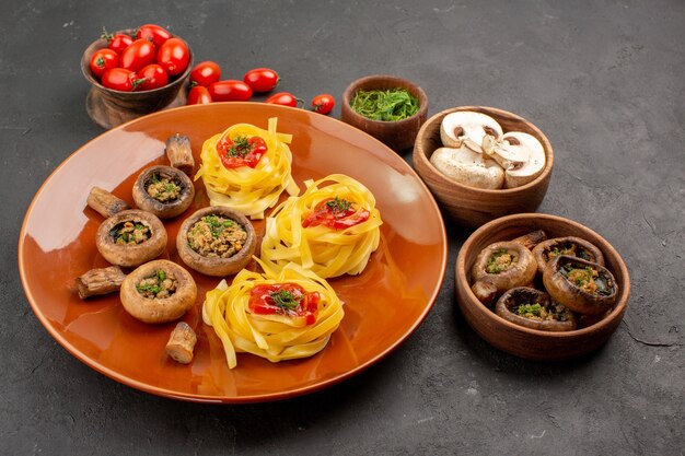 Vue avant de champignons cuits avec pâte de pâtes sur table sombre repas repas dîner