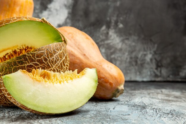 Vue avant de la citrouille fraîche au melon sur un fond sombre-clair