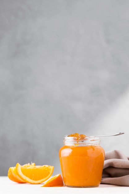 Photo gratuite vue avant de la confiture d'orange en pot transparent