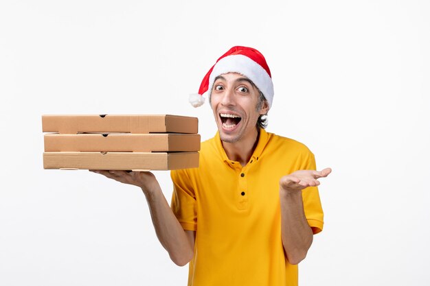 Vue avant de courrier masculin avec des boîtes de pizza sur le service de livraison uniforme de mur blanc