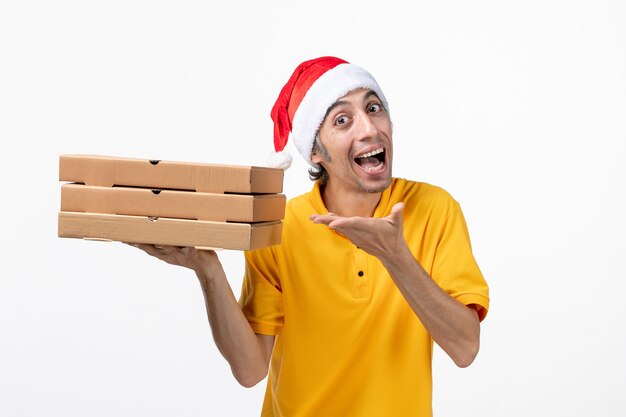 Vue avant de courrier masculin avec des boîtes de pizza sur le service de livraison uniforme de mur blanc