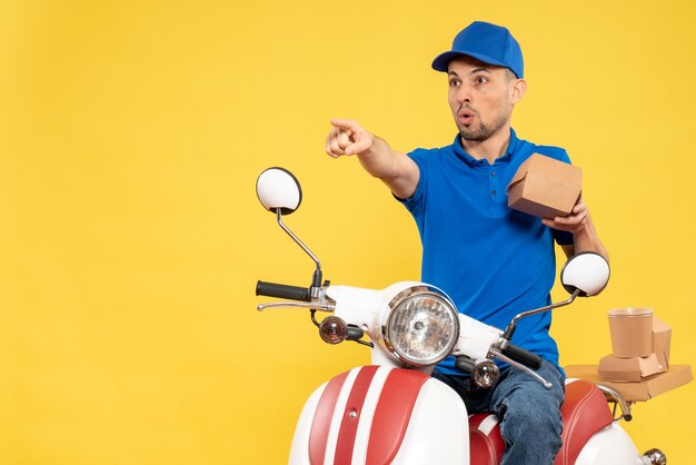 Vue avant de courrier masculin en uniforme bleu sur la livraison de travail jaune couleur travail travailleur service uniforme de vélo