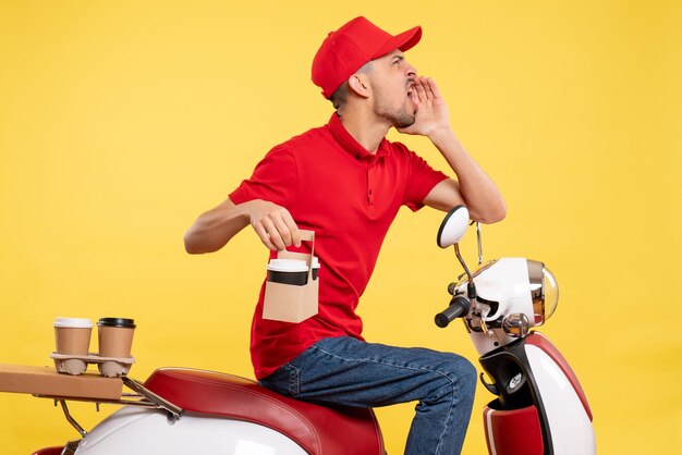 Vue avant de courrier masculin en uniforme rouge avec du café sur l'uniforme de couleur jaune vélo travail service de livraison d'emploi