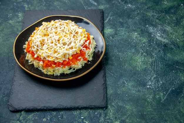 Vue avant de la délicieuse salade de mimosa à l'intérieur de la plaque sur une surface bleu foncé cuisine photo cuisine anniversaire repas de vacances couleur nourriture viande