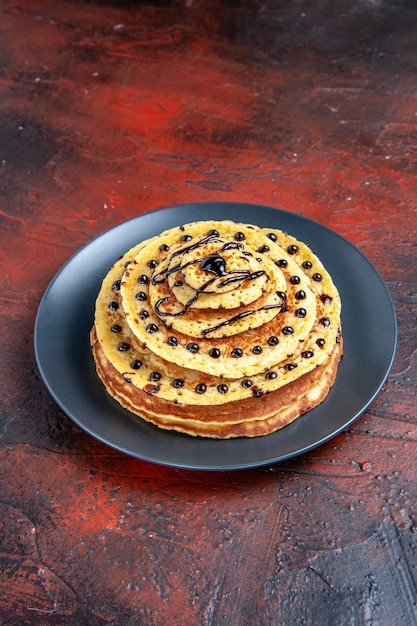 Photo gratuite vue avant de délicieuses crêpes sucrées avec glaçage sur fond sombre