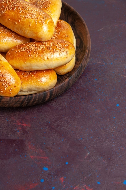 Photo gratuite vue avant de délicieuses galettes sucrées tartes au four pour le thé sur un bureau sombre