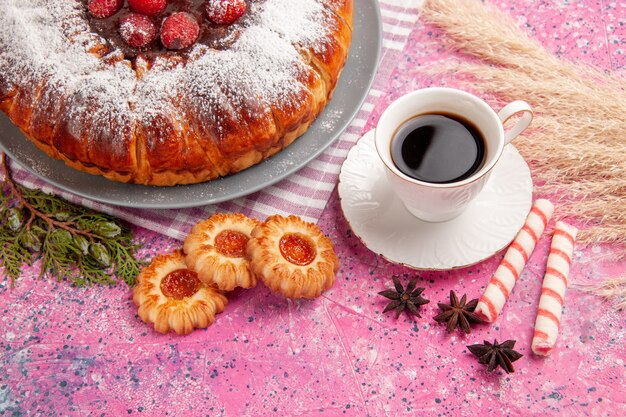 Vue avant de délicieux gâteau aux fraises sucre en poudre avec une tasse de thé et des cookies sur la surface rose clair gâteau biscuit biscuit sucré thé