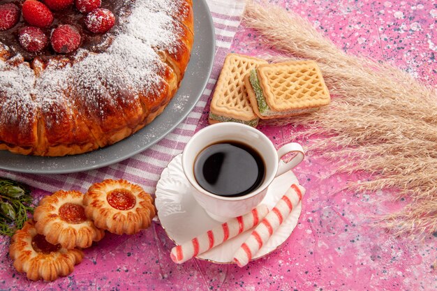 Vue avant de délicieux gâteau aux fraises sucre en poudre avec tasse de thé gaufres et biscuits sur surface rose clair gâteau biscuit biscuit sucré thé