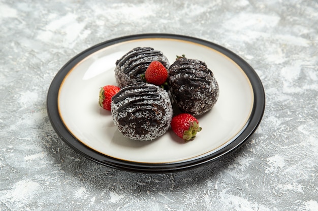 Photo gratuite vue avant de délicieux gâteaux au chocolat avec des fraises rouges fraîches sur la surface blanche cuire au four biscuit gâteau au sucre biscuit sucré chocolat