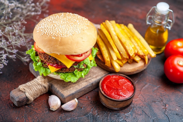 Vue avant de délicieux hamburger à la viande avec des frites sur le bureau sombre pain sandwich fast-food