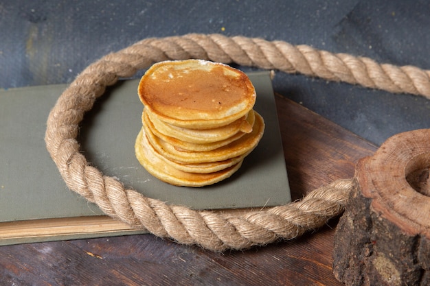 Vue avant de délicieux muffins délicieux avec des cordes sur le fond gris petit-déjeuner repas alimentaire crêpes sucrées