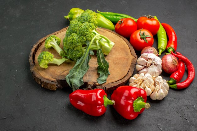 Vue avant du brocoli vert frais avec des légumes frais sur fond sombre