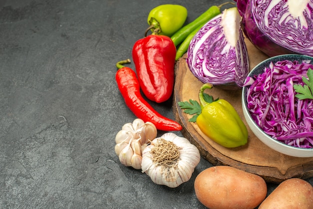 Vue avant du chou rouge avec des légumes frais sur la table grise salade de santé régime mûr