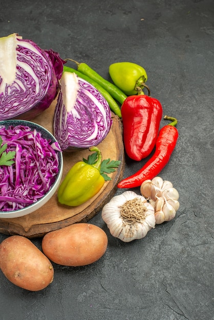 Vue avant du chou rouge avec des légumes frais sur la table grise salade de santé régime mûr