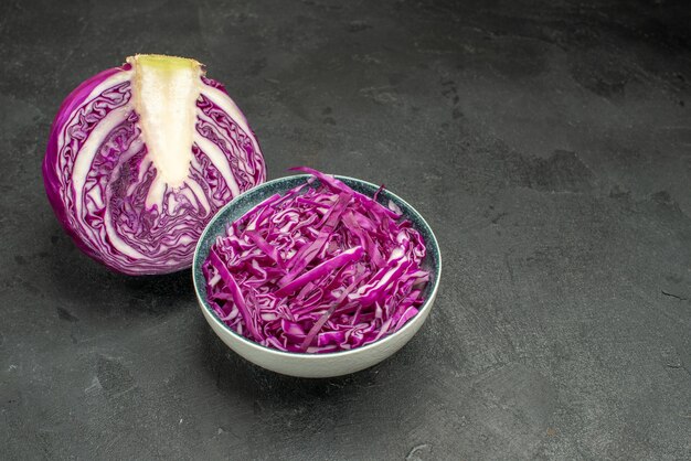 Vue avant du chou rouge en tranches de légumes frais sur la table sombre alimentation salade mûre santé