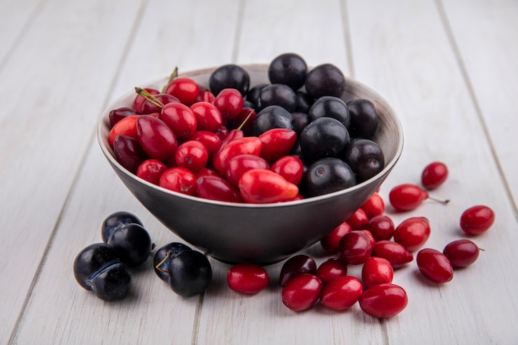 Photo gratuit vue avant du cornouiller avec prune cerise dans un bol sur fond blanc