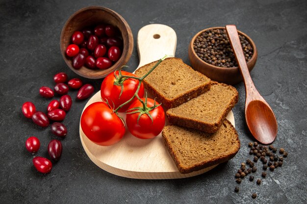 Vue avant du cornouiller rouge frais avec des miches de pain et des tomates sur l'espace gris