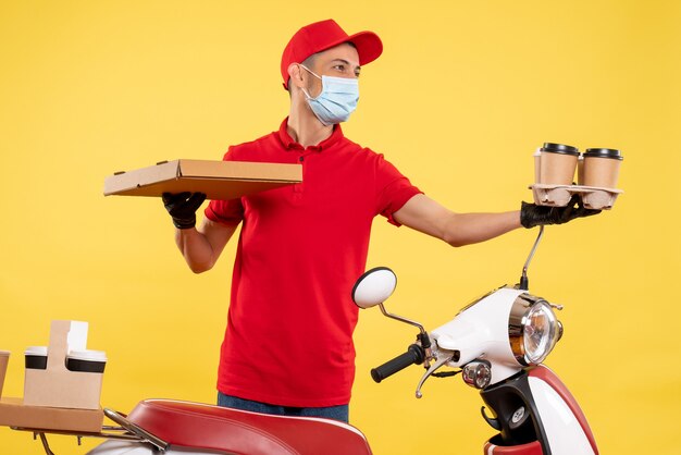 Vue avant du courrier masculin en uniforme avec du café et de la nourriture fort sur un service de pandémie jaune travail de travail uniforme de couleur virus virus covid