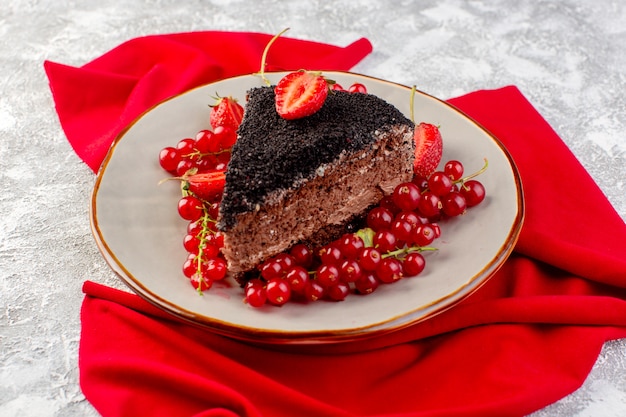 Vue avant du délicieux gâteau au chocolat en tranches avec de la crème choco et des canneberges rouges fraîches