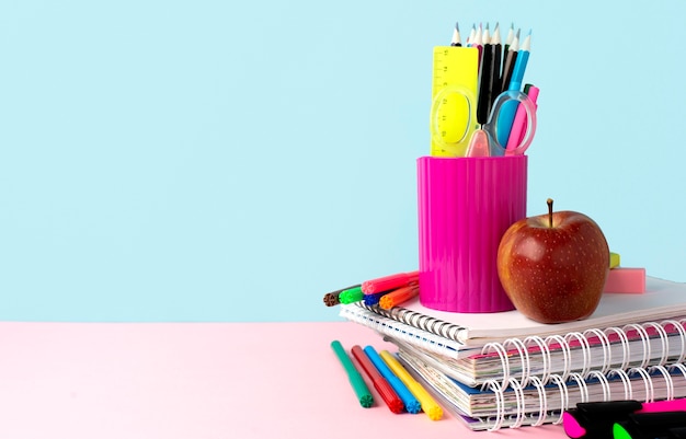 Vue avant du dos aux fournitures scolaires avec des cahiers et un espace de copie