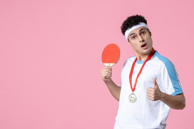 Vue avant du joueur masculin avec médaille tenant petite raquette