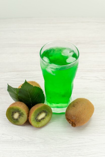 Vue avant du jus vert avec des kiwis frais sur une surface blanche