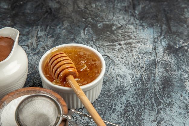 Vue avant du miel sucré avec du sucre sur la surface sombre de l'abeille à sucre miel