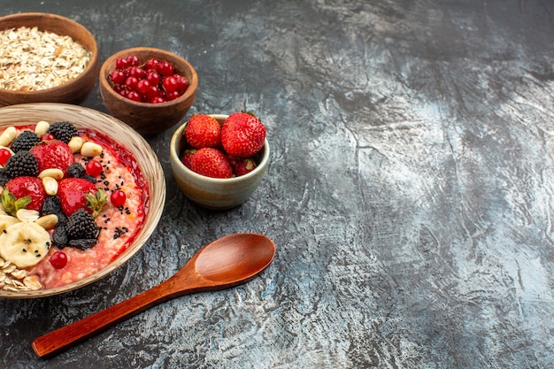 Vue avant du muesli fruité avec des fruits tranchés sur un fruit de santé de céréales de table clair-foncé