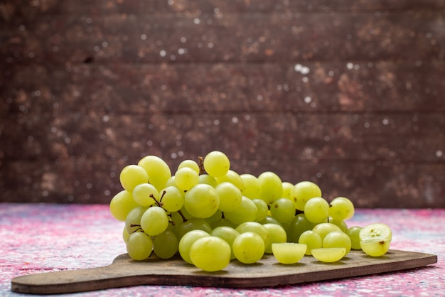 Vue avant du raisin vert frais fruits moelleux et juteux sur la surface lumineuse fruit mellow juteux violet