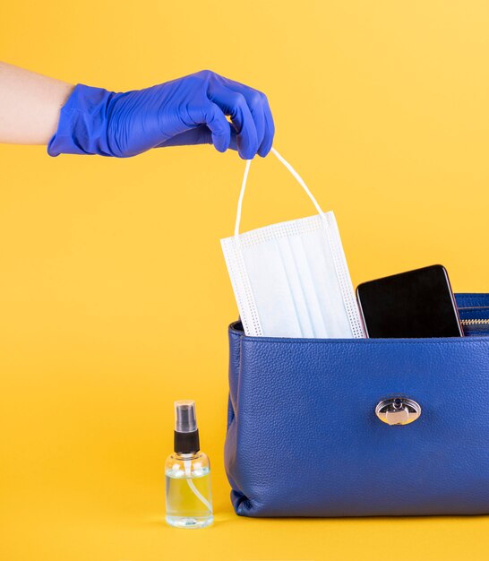 Vue avant du sac à main avec masque médical et désinfectant pour les mains