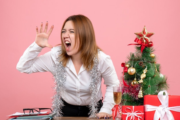 Vue Avant Du Travailleur Féminin Autour De Cadeaux De Noël Hurlant Sur Rose