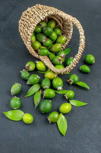 Vue avant de feijoas frais dans le panier sur une surface sombre