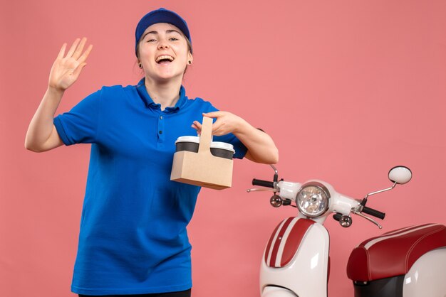 Vue avant femme courrier avec livraison de café sur l'uniforme de livraison de travail rose service travail travailleur vélo