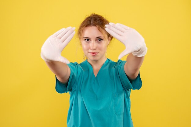 Vue avant femme médecin en chemise médicale avec des gants, couleur virus pandémique de l'émotion de la santé covid-19