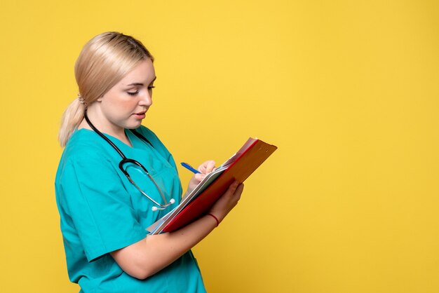 Vue avant femme médecin tenant des notes et des papiers, ambulance de virus Covid-19 infirmière hôpital médical