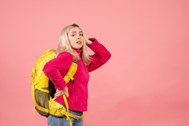 Vue avant femme voyageur avec sac à dos mettant la main sur une taille