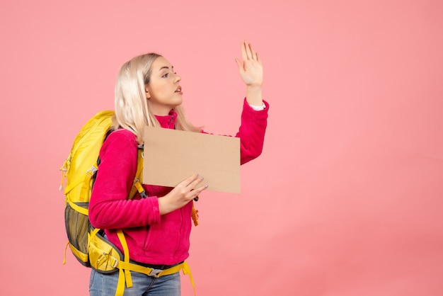 Vue avant femme voyageur avec sac à dos saluant quelqu'un