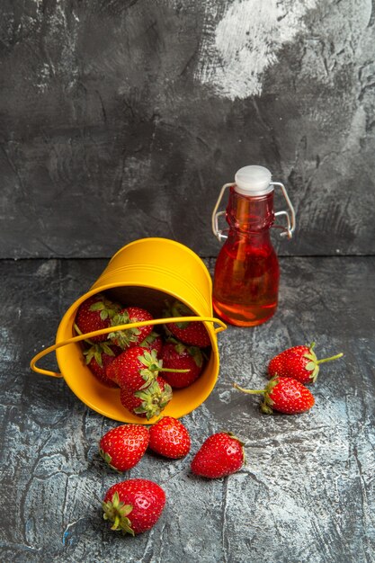 Vue avant des fraises fraîches à l'intérieur du panier sur un sol sombre