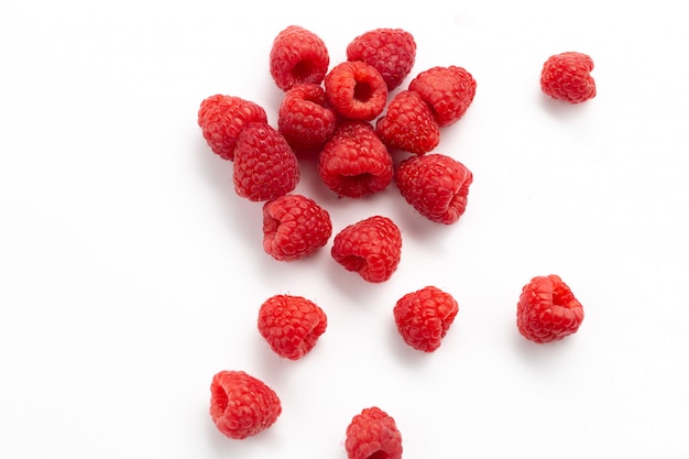 Vue avant de framboises rouges fraîches moelleuses et aigres sur blanc