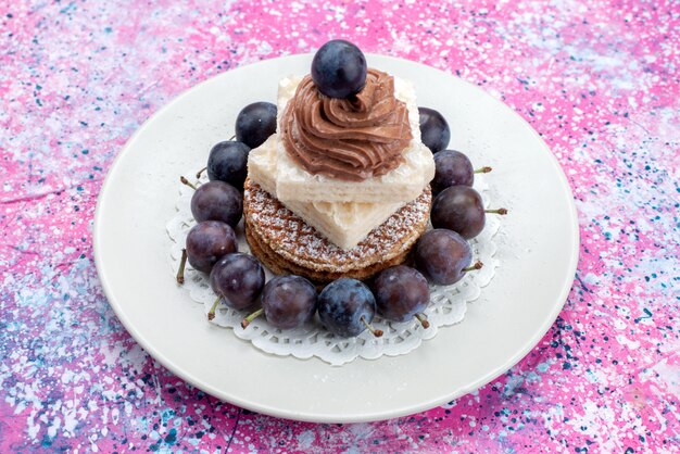 Vue avant des gâteaux gaufres avec de la crème et des raisins à l'intérieur de la plaque blanche