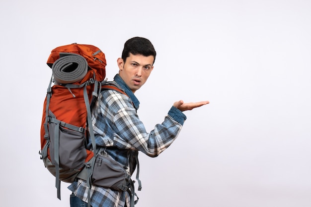 Vue avant de l'homme jeune voyageur avec sac à dos montrant quelque chose