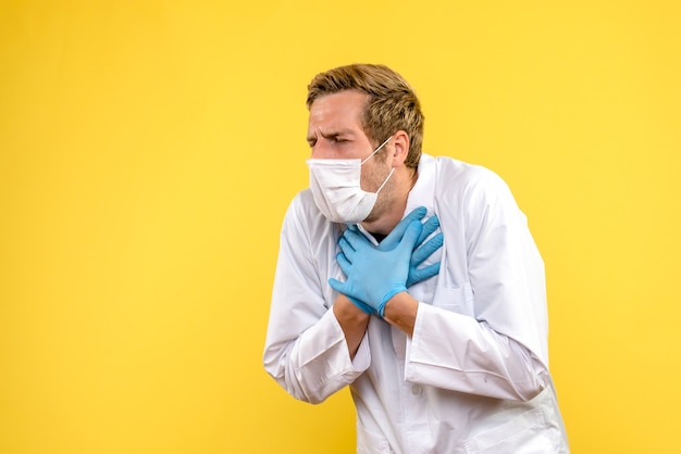 Vue avant de l'homme médecin ayant des problèmes respiratoires sur fond jaune santé pandémique medic covid-