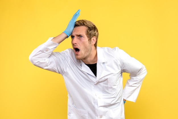 Vue avant de l'homme médecin excité sur fond jaune medic pandémie humaine covid