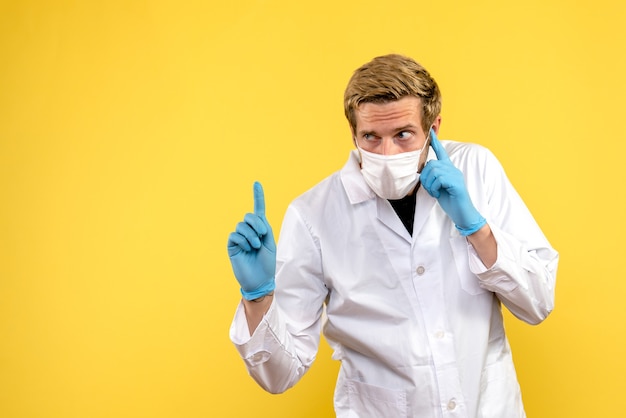 Vue avant de l'homme médecin sur fond jaune santé covid- medic