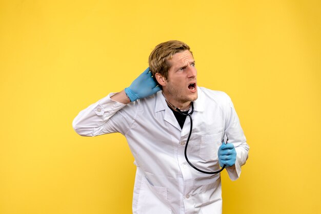 Vue avant de l'homme médecin sur fond jaune santé humaine virus medic